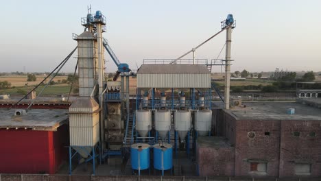 Drone-view-of-a-rice-and-flour-mill-and-agricultural-field-in-Pakistan,-village-life-in-Pakistan