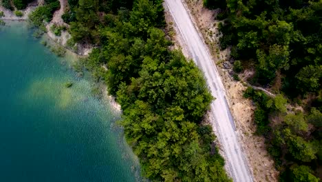 aerial view. flying over the beautiful lake and forest way. sunny day. aerial camera shot. landscape panorama.