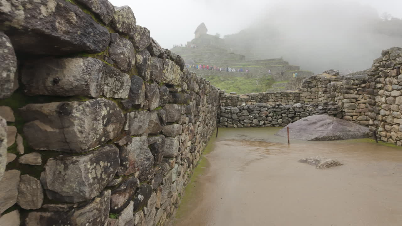 Slow motion video of Inca stone structures inside Machu Picchu, showing ancient walls and architecture in Peru