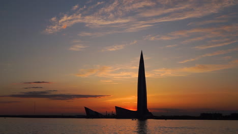 sunset silhouette of a skyscraper over the water