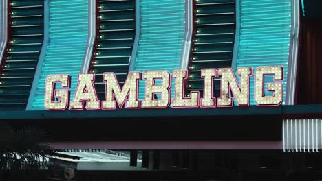 luces de neón brillan en dorado, rosa y azul para iluminar un letrero de juego en el distrito de fremont old town de las vegas