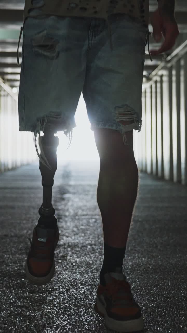 Man with Prosthetic Leg Walking Through a Tunnel