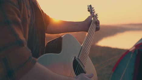 El-Hombre-Toca-Música-Con-La-Guitarra-En-El-Primer-Plano-Del-Campamento-Turístico.