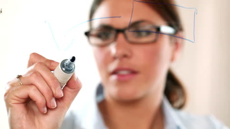 mujer de negocios dibujando diagramas en vidrio