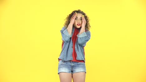 woman in denim jacket and red shirt, yellow background