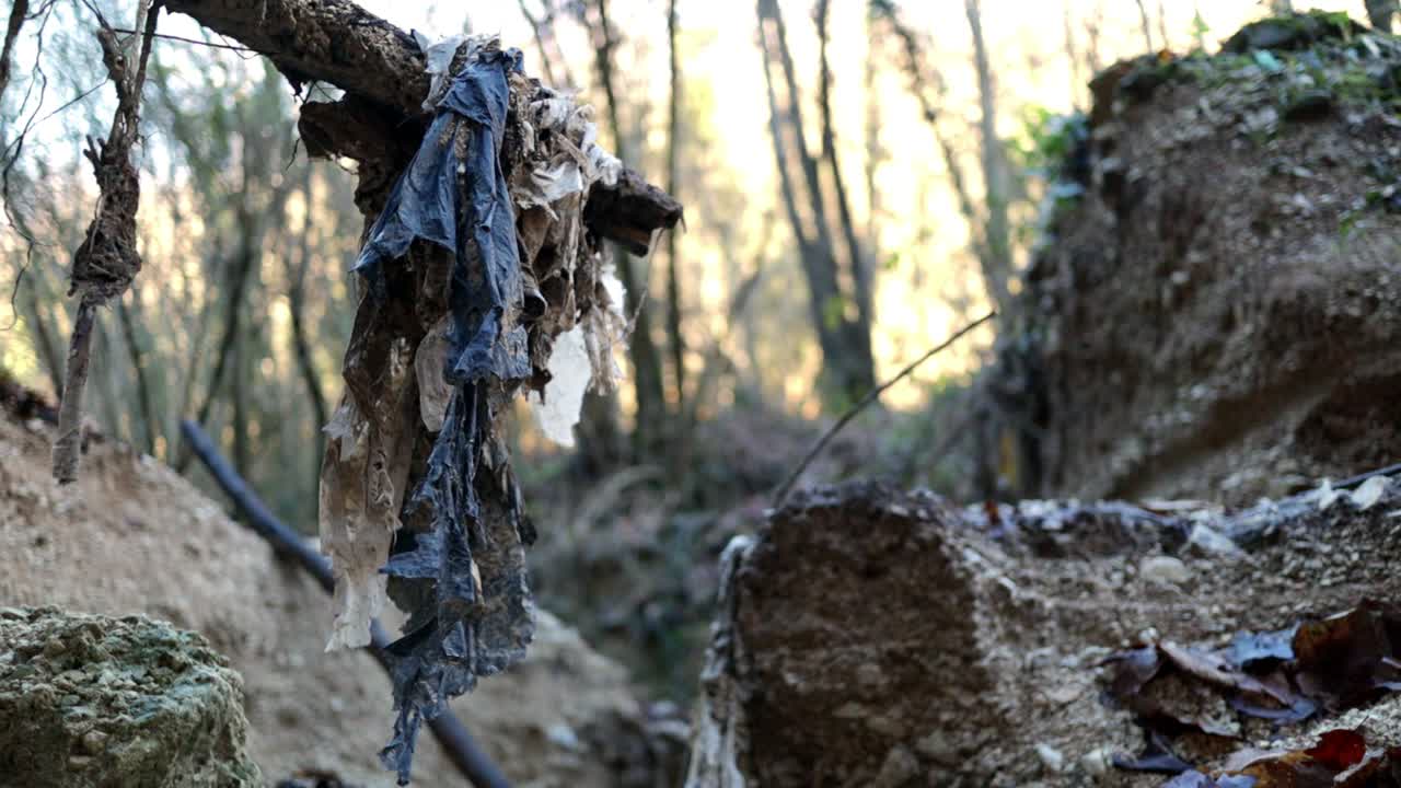 환경 오염, 마른 개울의 쓰레기, 오래된 폐기물이 바람에 펄럭입니다.