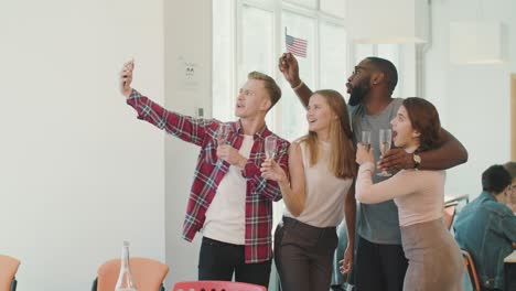 gente feliz haciendo selfies en el espacio de trabajo. equipo sonriente posando para la cámara.