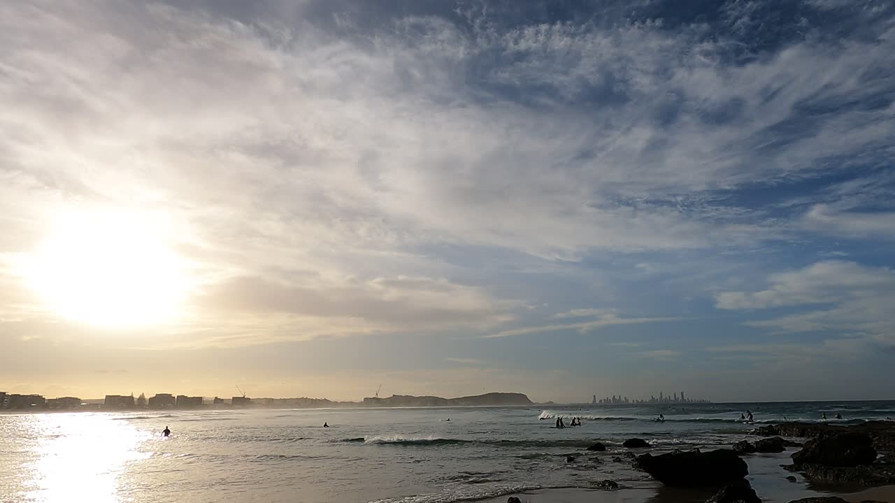 서퍼 들 은 활기찬 해 가 지는 동안 파도 를 즐긴다