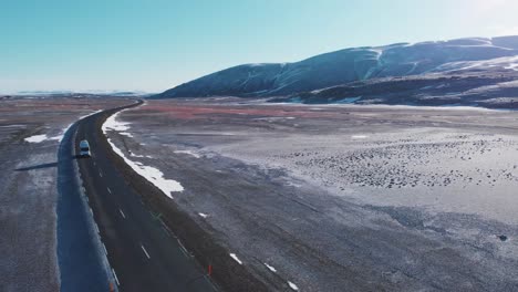 Modern-campervan-driving-on-a-road-in-snowy-mountain-plains-in-Iceland