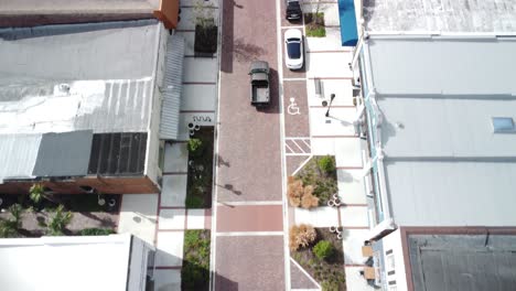 a dynamic drone shot follows a truck as it drives down a rustic brick road, showcasing its journey through a scenic landscape.