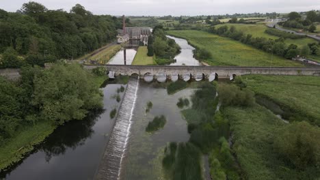 drone shot of a river with an old stone bridge crossing it