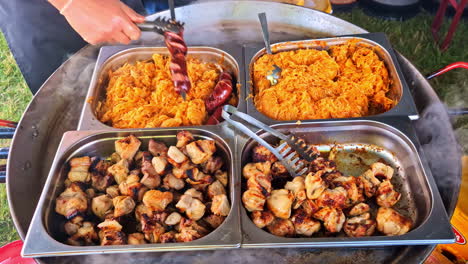 steaming trays of grilled meat and sauerkraut on large skillet at food market