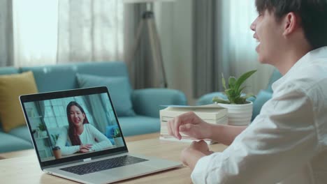 close up of asian man student having video call with a woman at home