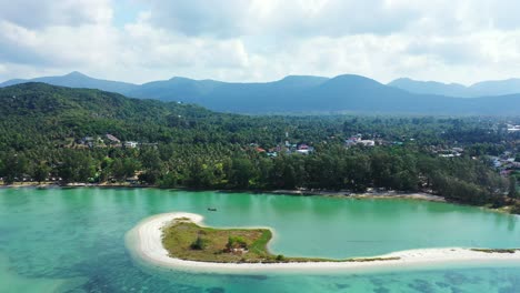 Breathtaking-panorama-with-small-tropical-island,-beautiful-clear-ocean-with-corals-and-mountains-in-the-background