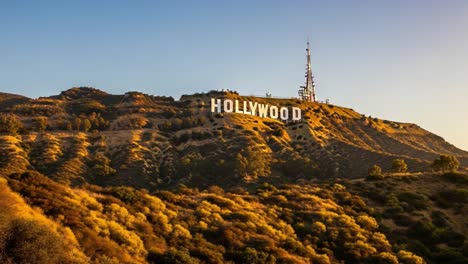 stunning view of the iconic hollywood sign gracing the hillside, captured in majestic light during sunset with lush greenery surrounding the landmark