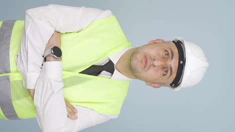 Vertical-video-of-Looking-up,-the-engineer-is-holding-his-hard-hat.