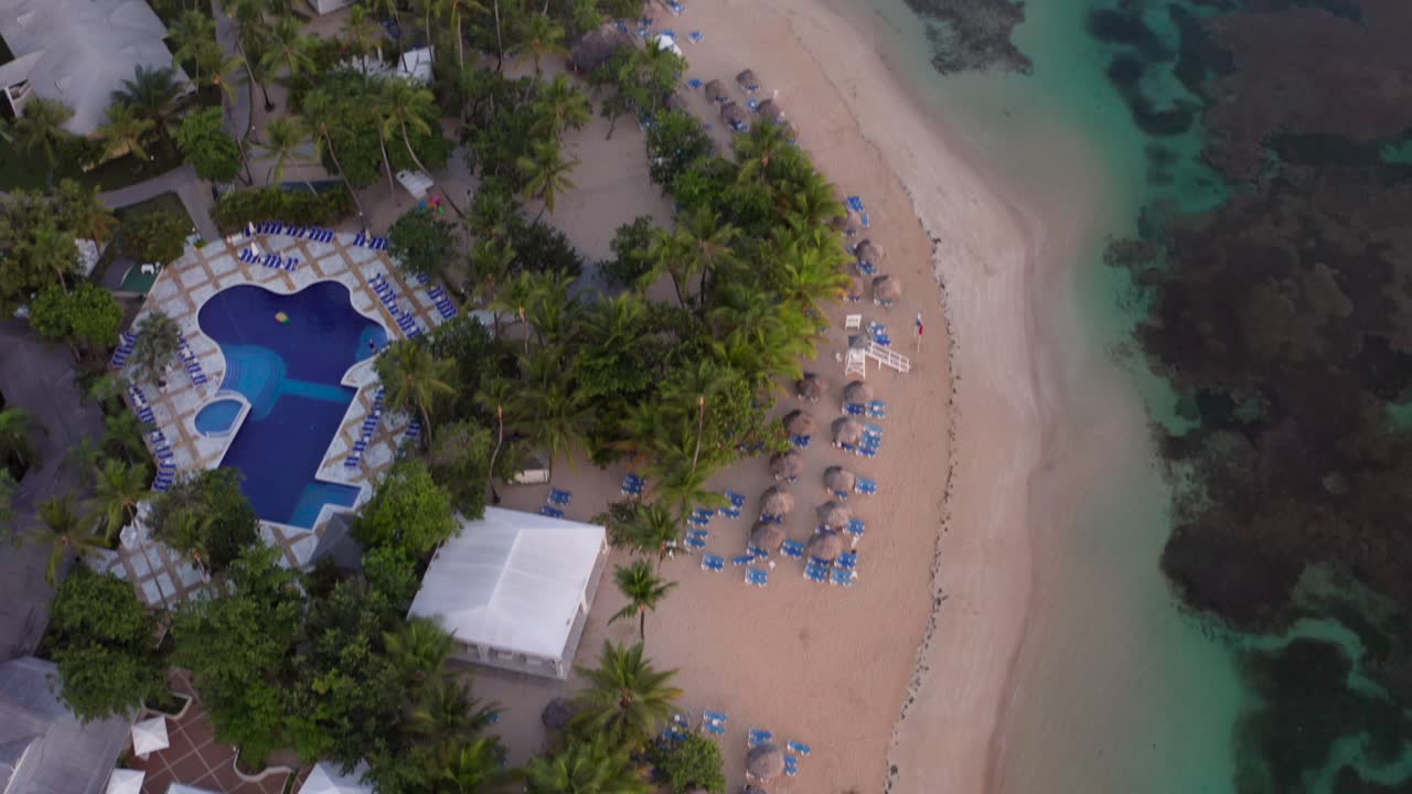 vista de avión no tripulado del océano, barco, sombrillas y playa de arena del caribe al amanecer, playa de grand bahia príncipe en la península de samaná, república dominicana