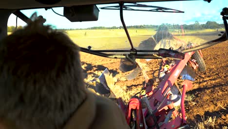 farmer turning around the reversible plough at the end of the field