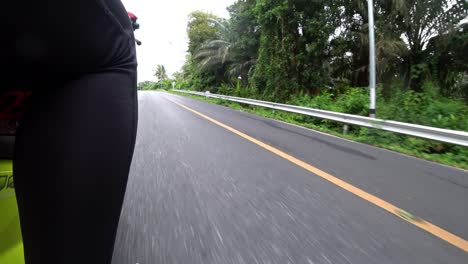 view of road and the leg of a girl on a motorcycle