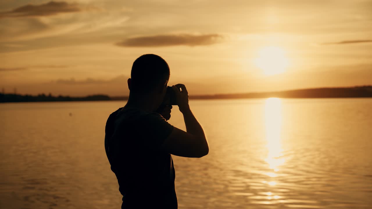 Silhouette of photographer taking photos in the river at sunset time.