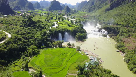 ban gioc waterfalls on a sunny day with lush green fields around