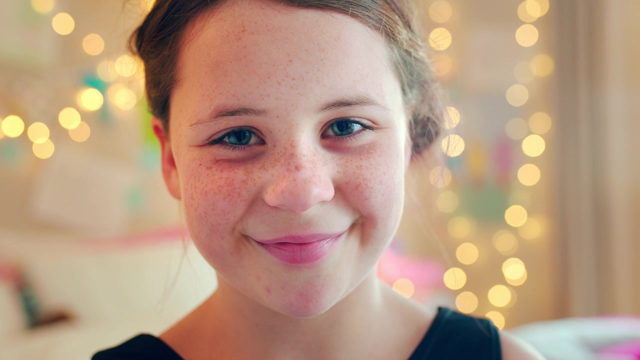 Portrett av en ung jente som smiler til kameraet