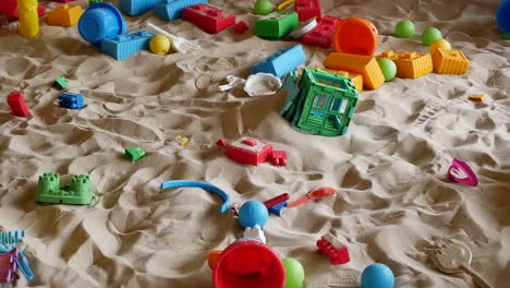 messy sandpit with children's toys