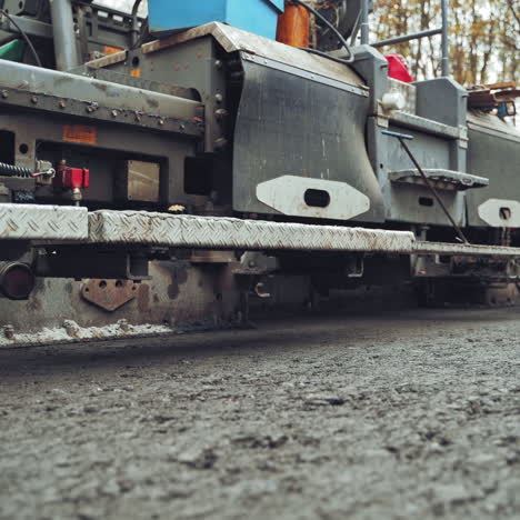 close up asphalt laying machine. asphalt paver. tarmac road laying machine. asphalt spreader. road construction. slow motion