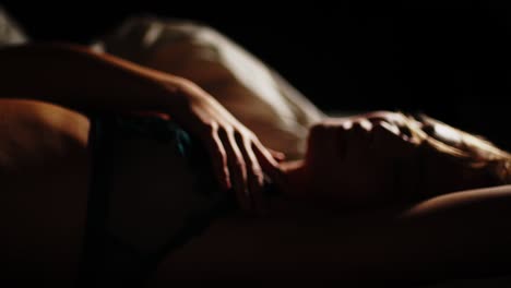 dreamy shot of a sensual woman dressed in lingerie slowly caressing her upper body with the camera going in and out of focus