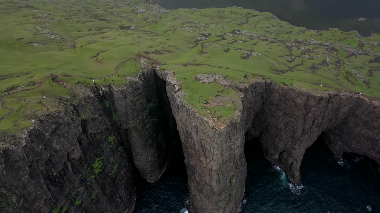 Tall Faroe Islands clifftop coastline, with Sørvágsvatn lake behind, aerial reveal