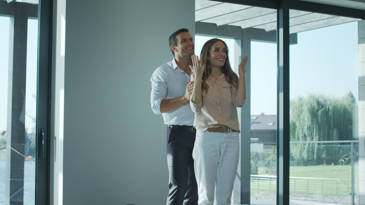 Hombre contento tapando los ojos a mujer en casa nueva. Esposa feliz disfrutando de una casa de lujo.