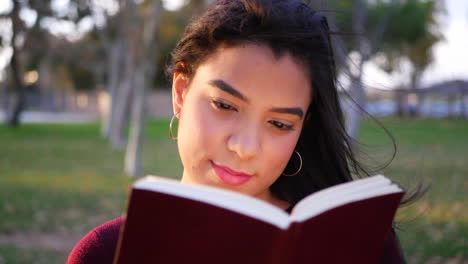 cierre a una estudiante universitaria leyendo y estudiando un libro de texto antes de la clase en el campus a cámara lenta