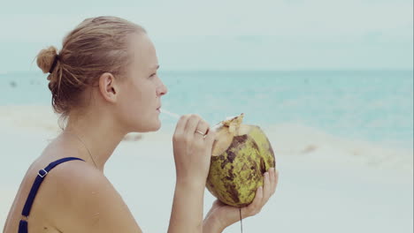 Frau-Am-Strand-Trinkt-Aus-Kokosnuss