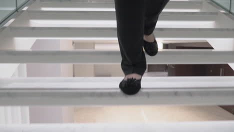 a steadicam shot of female feet going downstairs