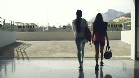 rear view of two young female athletes walking to