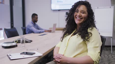 Portrait-of-smiling-biracial-businesswoman-looking-at-camera-in-modern-office