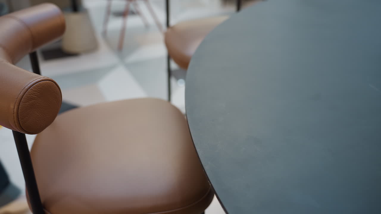 조용한 쇼핑 휴식, 쇼핑 시간을 멈추고 부드럽게 기다리기, 쇼핑백과 의자들 사이 차분한 가죽 좌석, 쇼핑몰 테이블에서 쇼핑백으로 둘러싸인 빈 가죽 안락의자