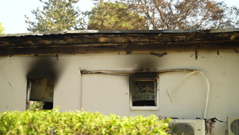 home in kibbutz be'eri was attacked on october 7th, remnants of the house are burned, windows are scorched