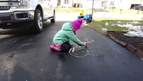 Girl-using-sidewalk-chalk-on-sunnyday