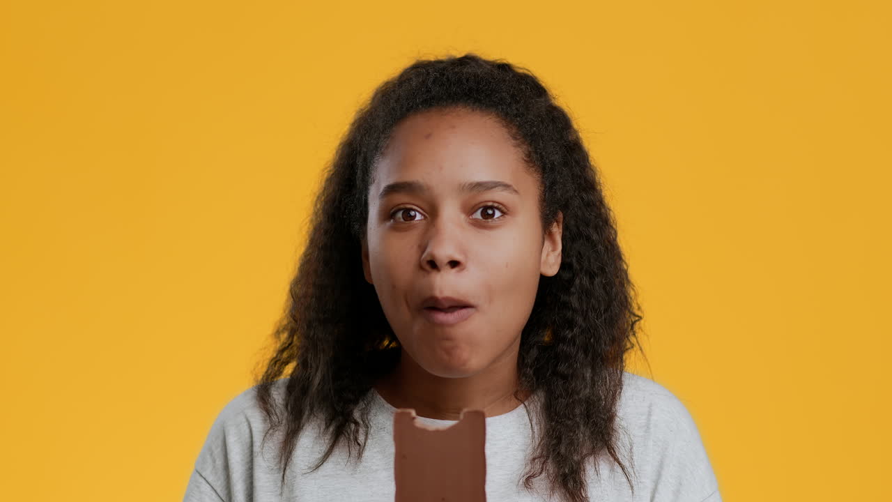 una chica comiendo una barra de chocolate.