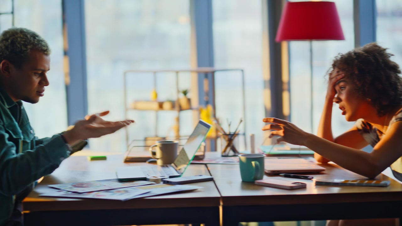 Stressed woman working laptop office. Coworkers arguing over deadline stress