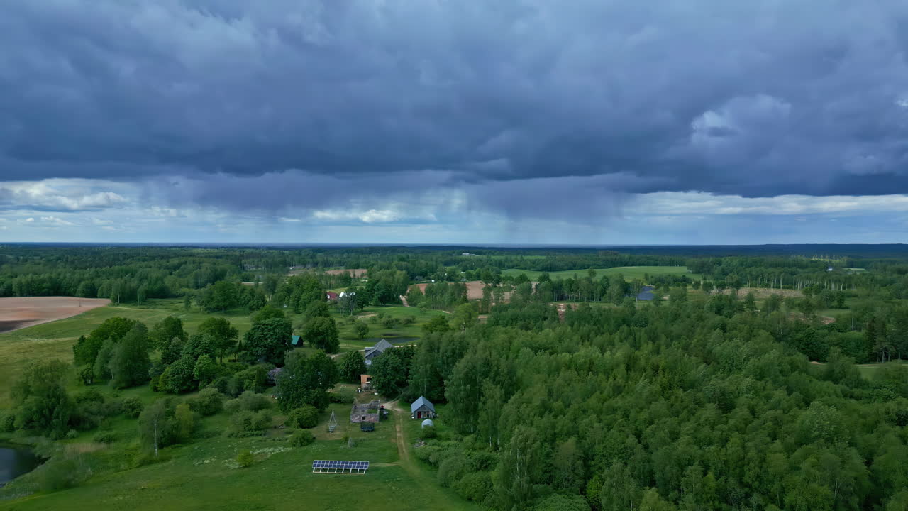 Luftfoto med drone af et grønt landskab og regn i det fjerne