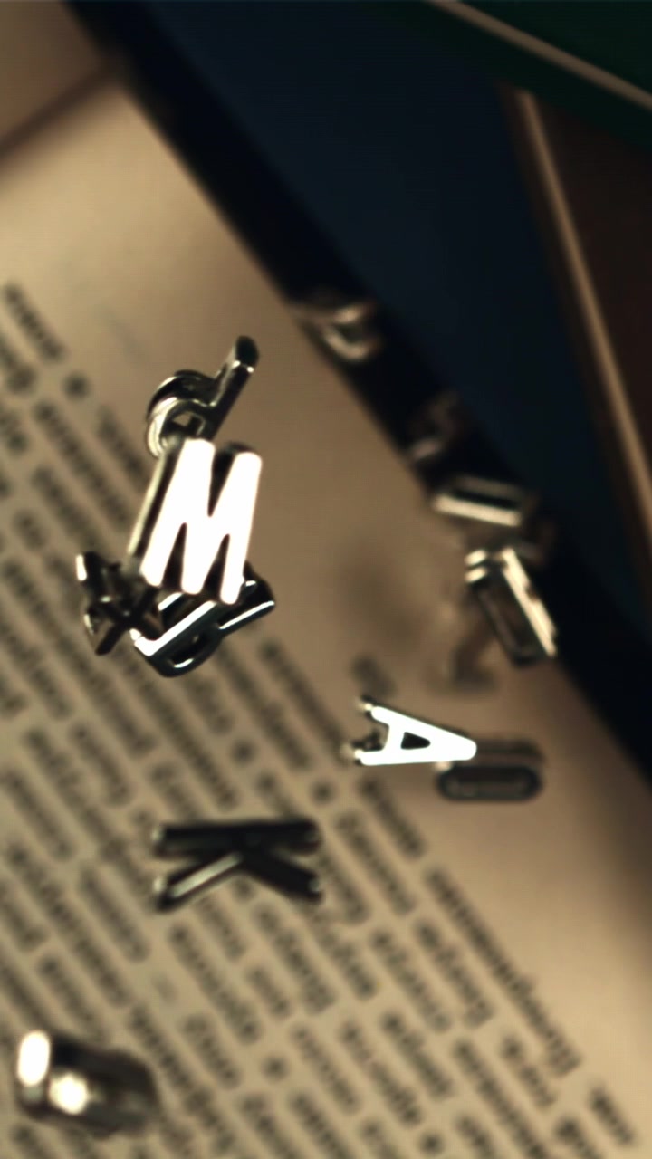 Slow Motion of Metal Letters Falling on an Open Book