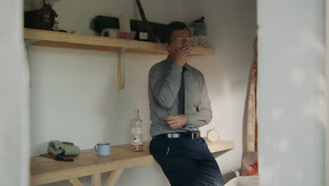 man smoking and stressed in a shed