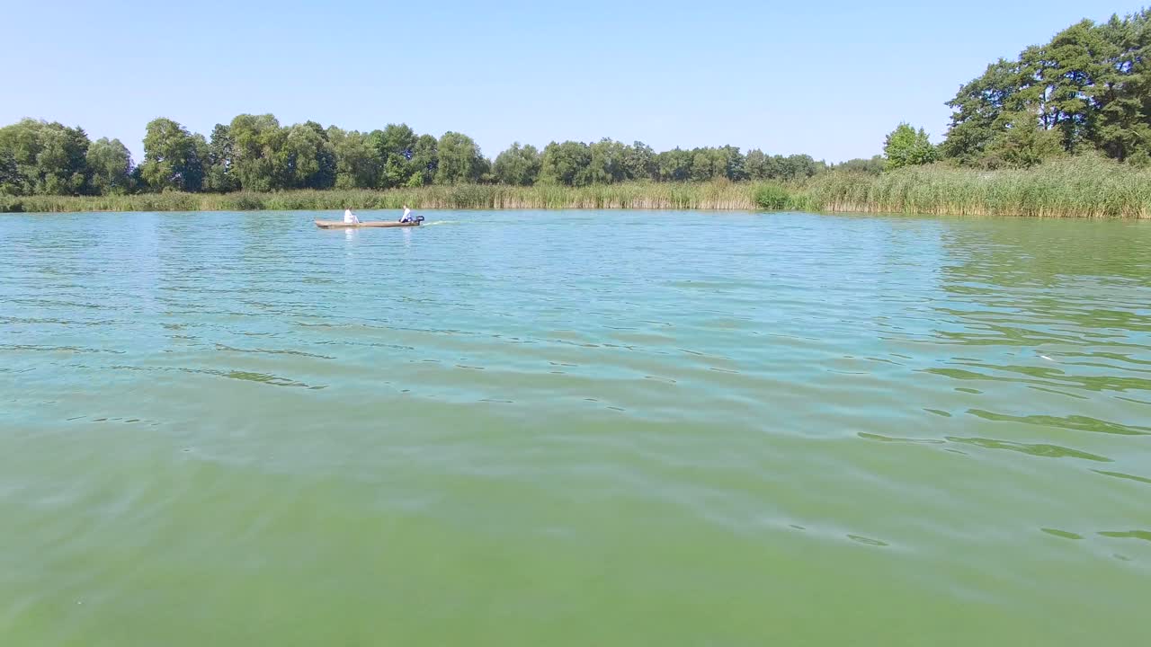 Lovers ride in a boat. Aerial view of couple rowing boats on the river