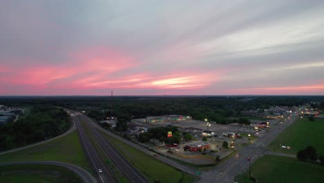 una toma aérea de un hermoso cielo rosa sobre la concurrida carretera de tráfico al atardecer
