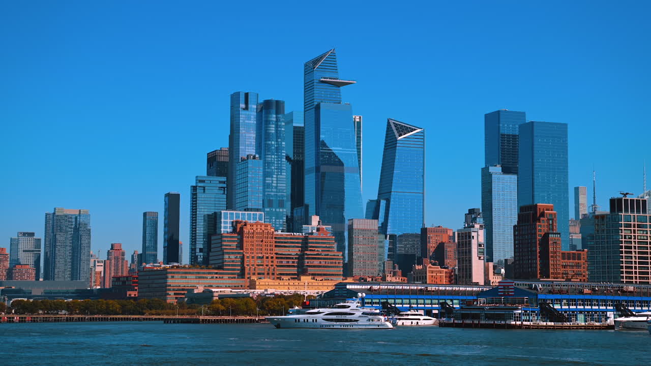 Boats stand at the pier of the East River. Spectacular glass skyline of New York from the riverscape