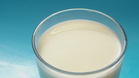 "una dulce armonía: una galleta cayendo sobre un vaso de leche azul