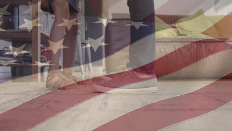 animation of flag of usa waving over foot of african american father dancing with daughter