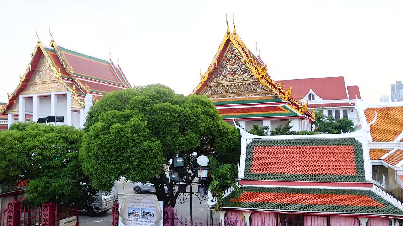 Aerial footage of Prayurawongsawat Temple in Bangkok, showcasing traditional architecture and lush greenery under bright daylight